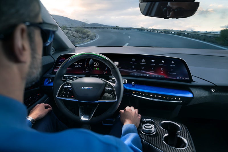 Front View of the 2026 OPTIQ-V Driving Through the Dusk Utilizing its Headlights | Romain Cadillac in Evansville IN